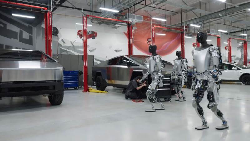 A group of Tesla Optimus robots in a factory setting