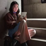 iPad mini 8 battery: woman using the new iPad mini on concrete stairs