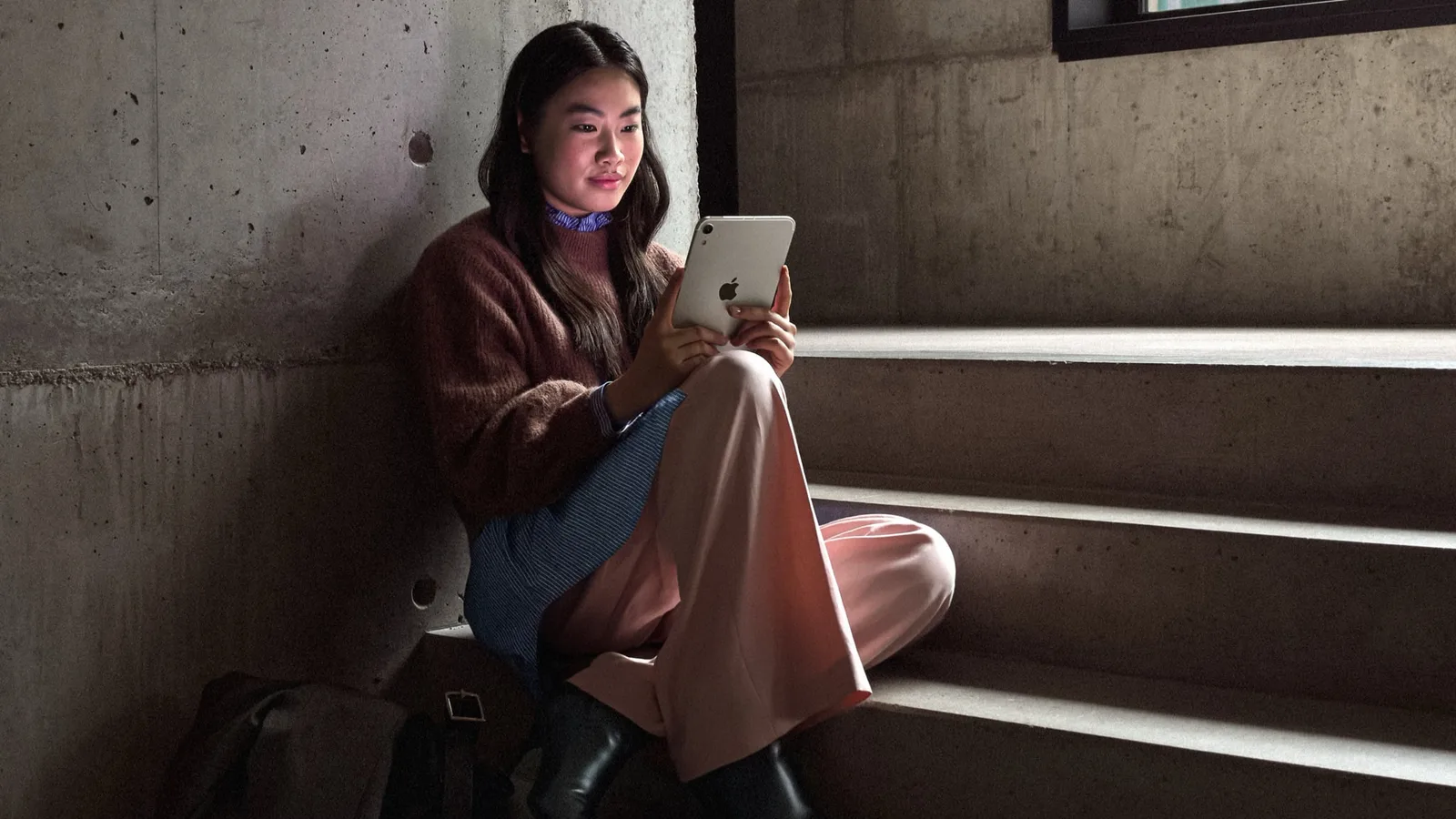 iPad mini 8 battery: woman using the new iPad mini on concrete stairs